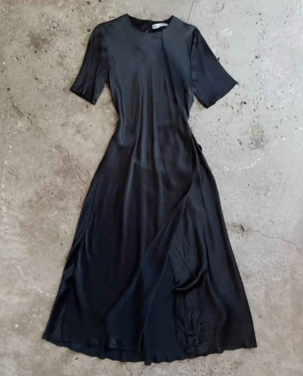 Vestido largo negro con mangas cortas y corte asimétrico que se abre con tajo. Ideal para eventos formales o salidas nocturnas. hombros 38 axilas 36-45 largo 138. la tela es un negro semi brillante
