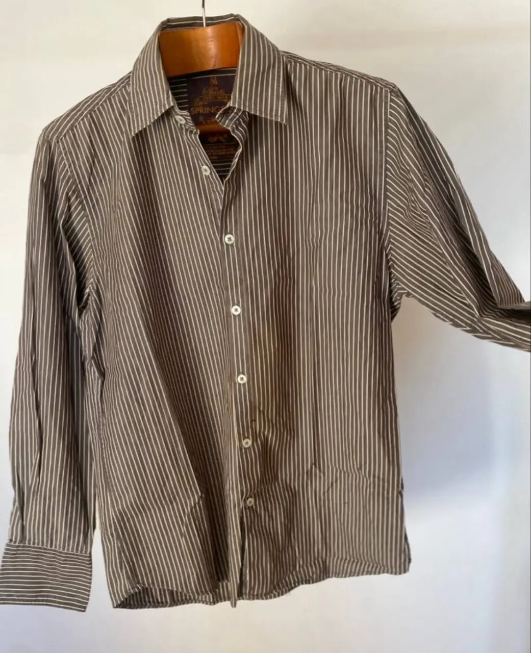 Camisa a rayas marrón y blanca de hombre, manga larga, con cuello clásico y cierre de botones. Ideal para un look casual o semi formal.