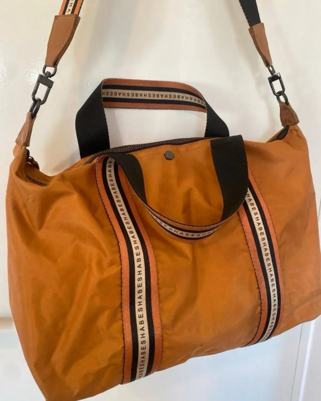Bolso de viaje naranja con detalles en negro y blanco. Ideal para llevar todo lo necesario con estilo. Perfecto para escapadas de fin de semana o viajes cortos. Diseño resistente y funcional. Tiene detalles x eso el precio. 50x34