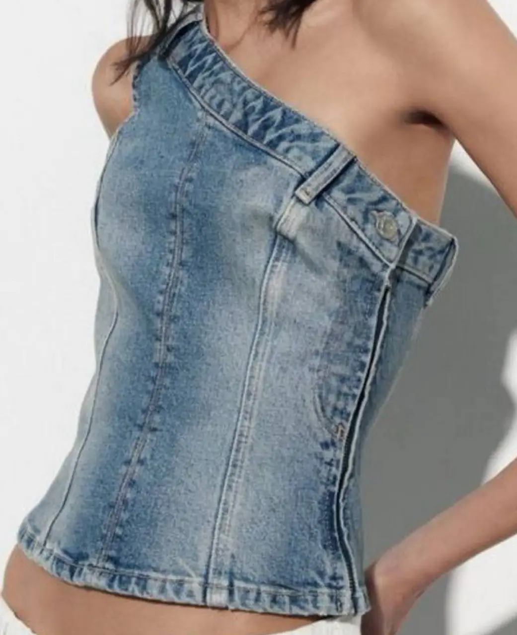 Top asimétrico de jean, con un diseño único de un solo hombro. Confeccionado con detalles de costura y un cierre lateral. Ideal para un look moderno y audaz. axilas 41largo desde el hombro 55 cintura 37 aproxla primera foto es un modelo similar no es exactamente el mismo pero queda prácticamente así