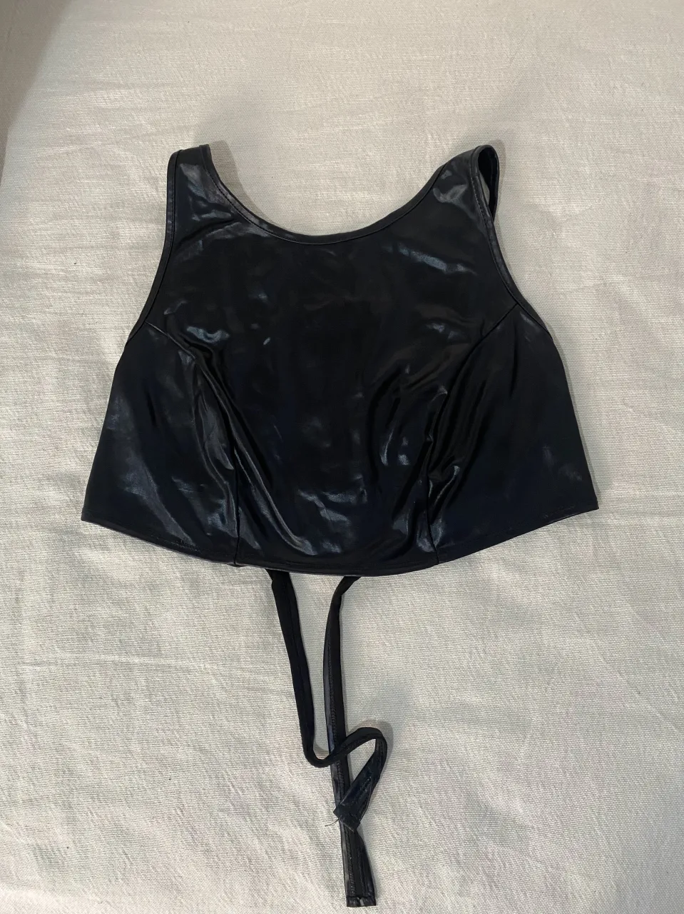 Top negro estilo Y2K, con tiras para atar en la espalda. Ideal para looks audaces y modernos.