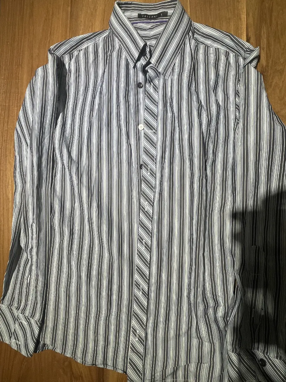 Camisa a rayas verticales en tonos grises y blancos, de manga larga. Ideal para un look casual o de trabajo. Marca Tascani, talle L.