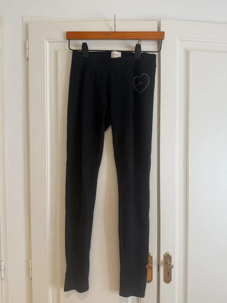 Calza negra con detalle de corazón bordado en dorado con las iniciales GH. Ideal para un look comfy y casual. Talle XS.