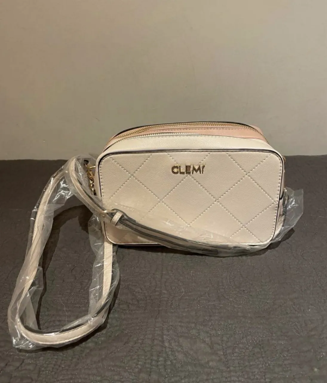 Cartera bandolera de cuero sintético, diseño acolchado con rombos. Posee dos compartimentos con cierre y correa regulable. Ideal para el día a día o para complementar un look casual.