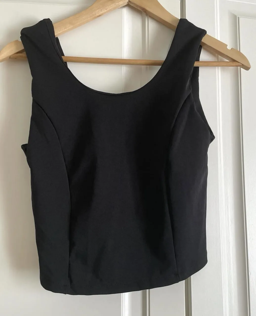 Top negro Sofi Caputo, ideal para un look canchero y moderno. Perfecto para combinar con jeans o faldas.