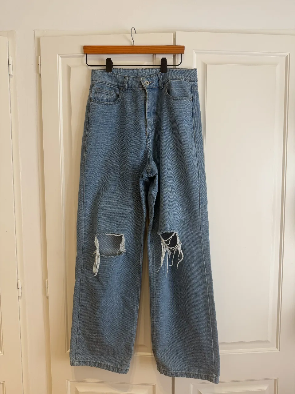 Jeans tiro alto, corte recto y ancho, con roturas desgastadas en las rodillas. Un clásico reinventado para un look moderno y canchero. Ideales para combinar con tops o remeras básicas.