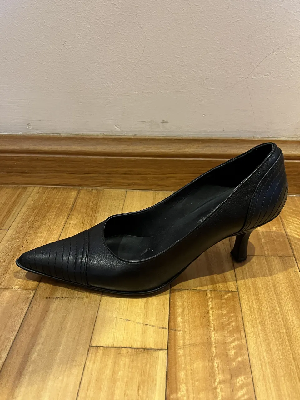 Tacos negros de cuero, con punta fina y detalle de costuras en la punta y en el talón.