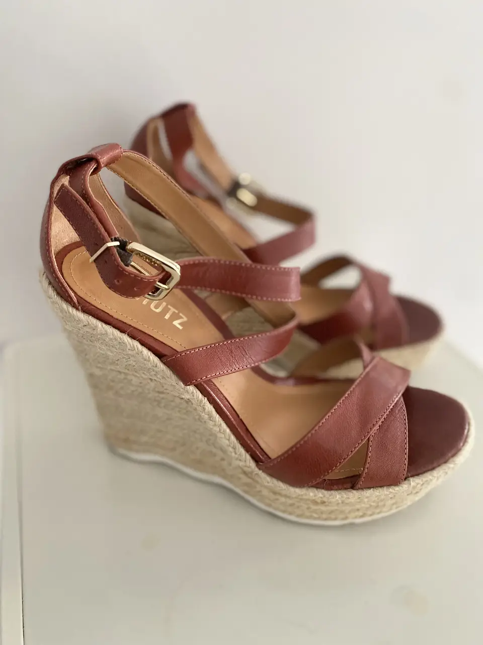 Sandalias de cuña con tiras de cuero marrón y detalle de yute en la suela. Ideales para un look de verano.