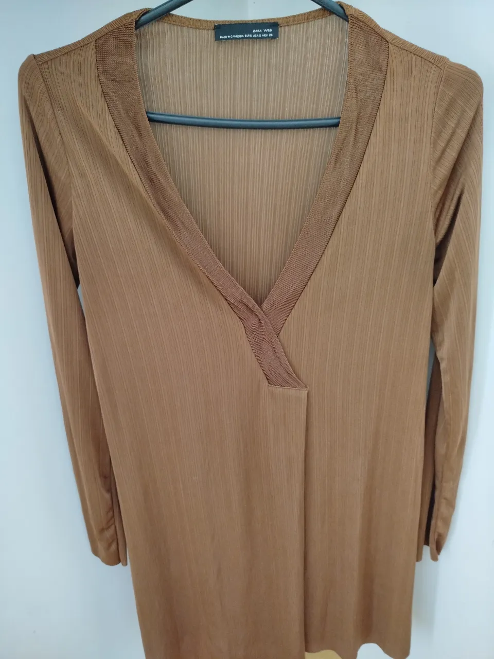 Blusa manga larga de color marrón con cuello en V, ideal para un look elegante y sofisticado. Confeccionada en un tejido suave y ligero, perfecta para combinar con pantalones de vestir o faldas.