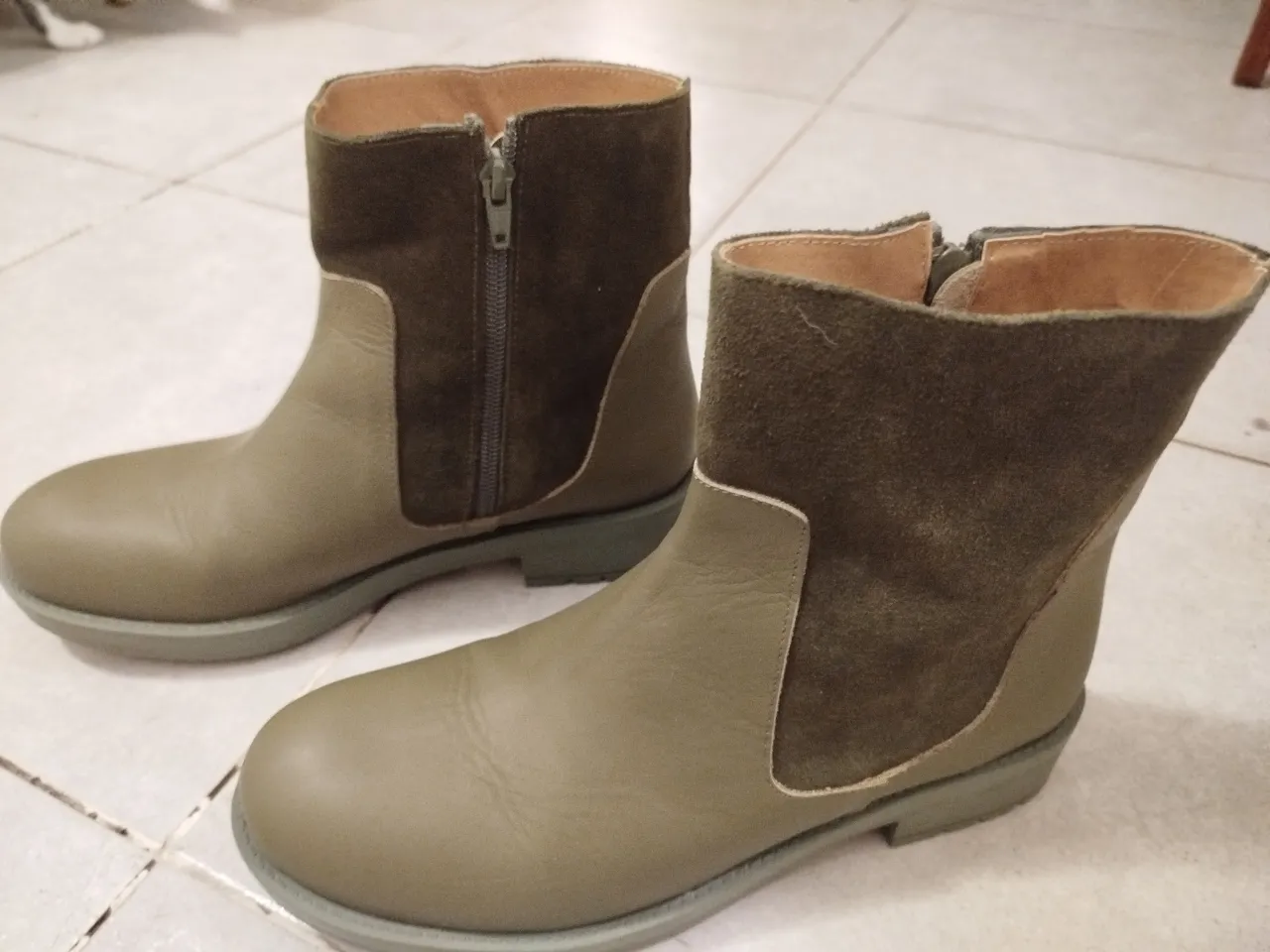 Botines de cuero vacuno en color verde oliva con detalles en gamuza marrón. Diseño moderno con cierre lateral y suela de goma. Ideales para un look casual y cómodo.