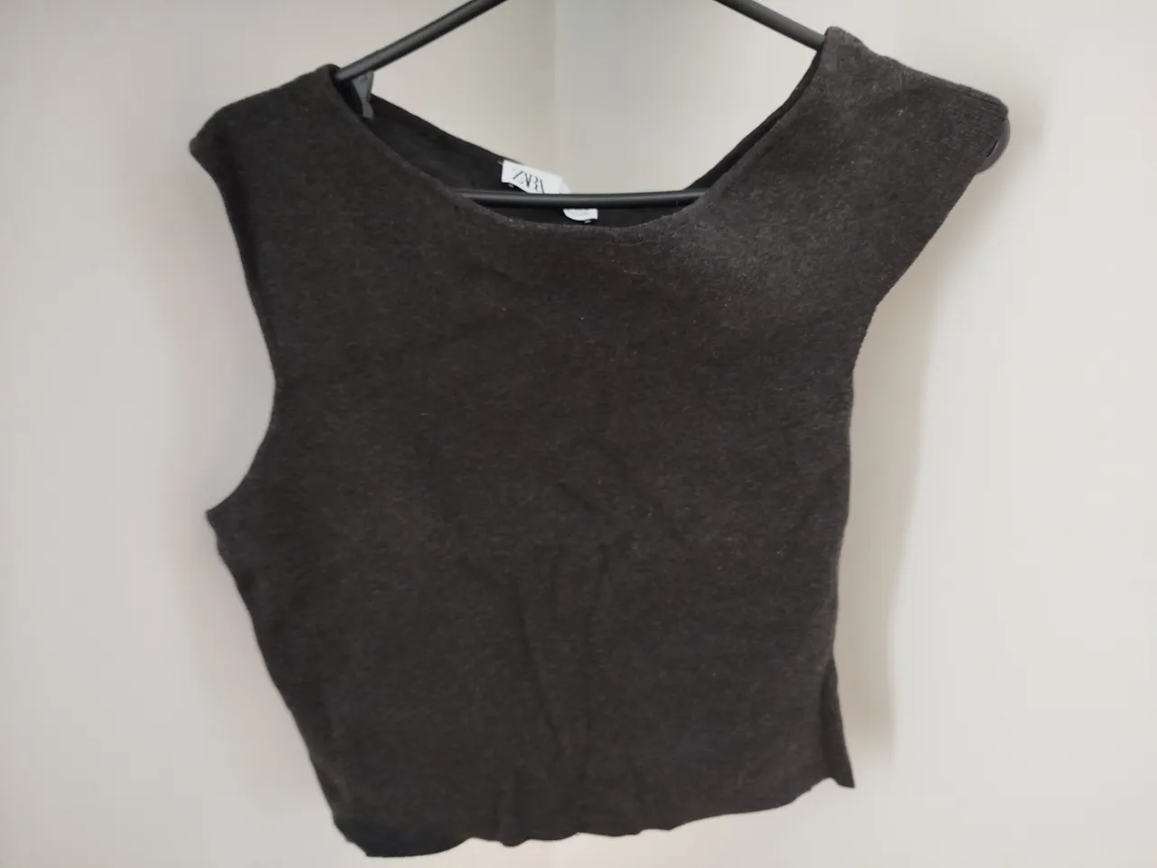 Top sin mangas de color gris oscuro, ideal para un look casual y moderno. Perfecto para combinar con jeans o faldas.