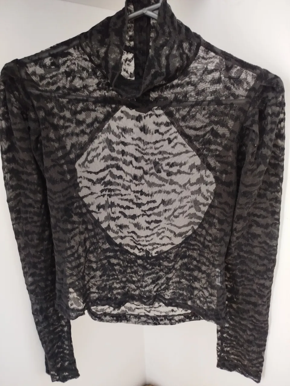 Blusa de encaje transparente con cuello alto y mangas largas. terciopelo animal print negro sobre tul . Ideal para un look sofisticado y moderno. botones en la espalda y espalda descubierta. hombros abuchonados corte princesa. muy original y un excelente diseño