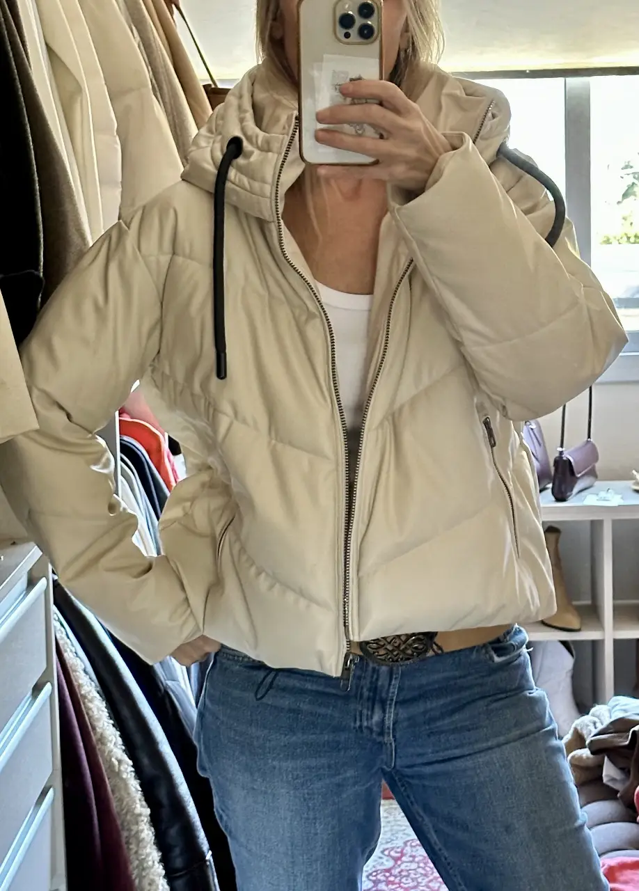 Campera puffer de mujer en color crudo, con capucha y cierre. Ideal para el invierno, con un diseño acolchado y un estilo casual.