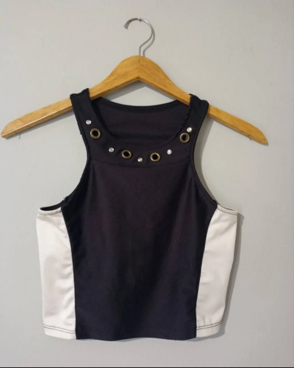Top  negro con detalles plateados en el cuello y recortes laterales blancos. Ideal para salir o para un look urbano.