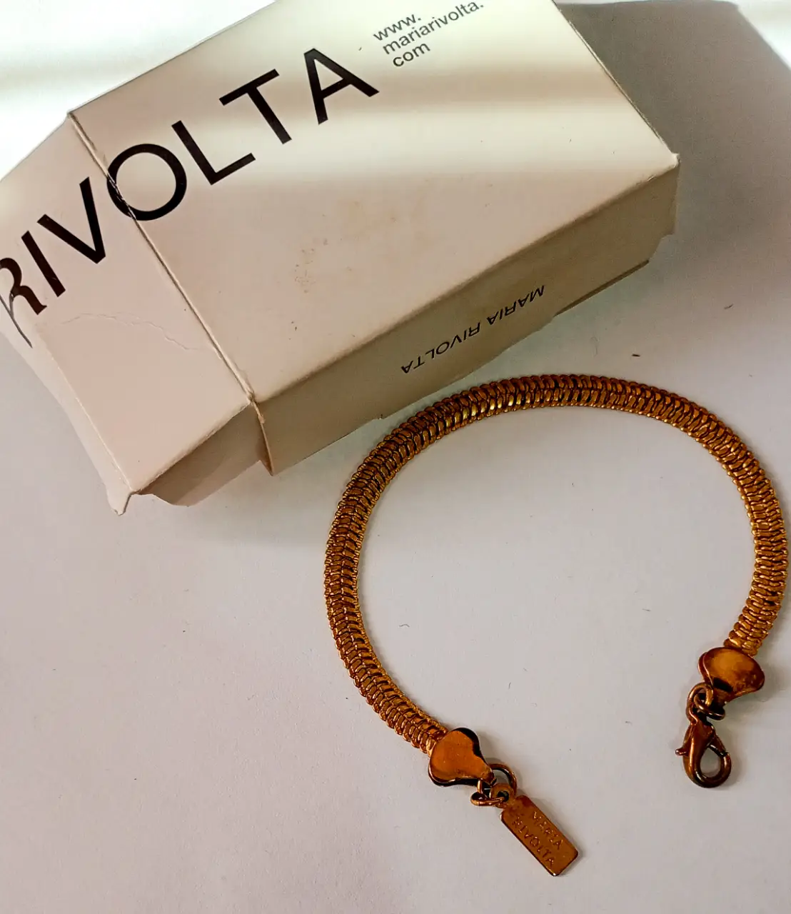Pulsera dorada de la marca Maria Rivolta. Diseño de cadena con eslabones entrelazados, ideal para un look elegante y sofisticado.