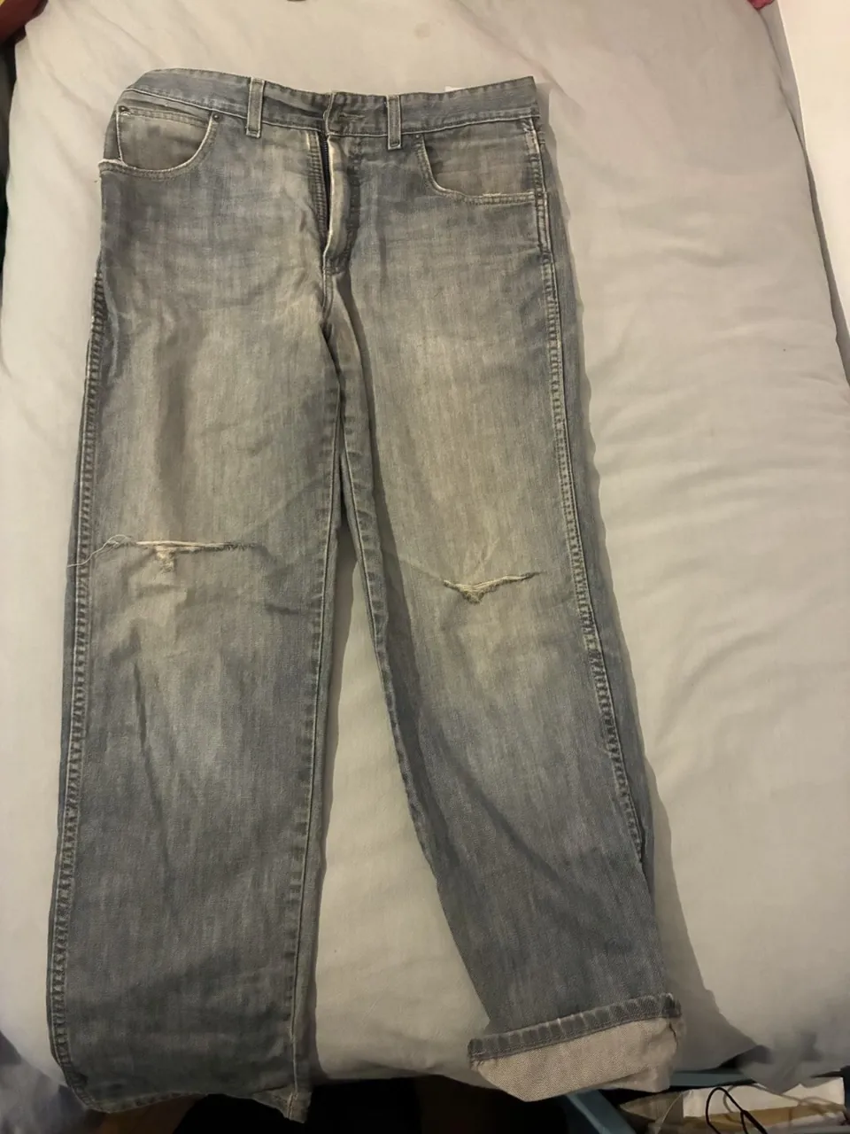 Jeans rectos de mujer, color gris gastado con roturas en las rodillas. Tiro medio y corte clásico, ideal para un look casual y moderno.
