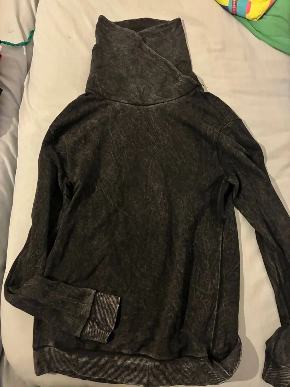 Buzo de cuello alto para mujer, de color gris oscuro con efecto desgastado. Ideal para un look casual y cómodo.