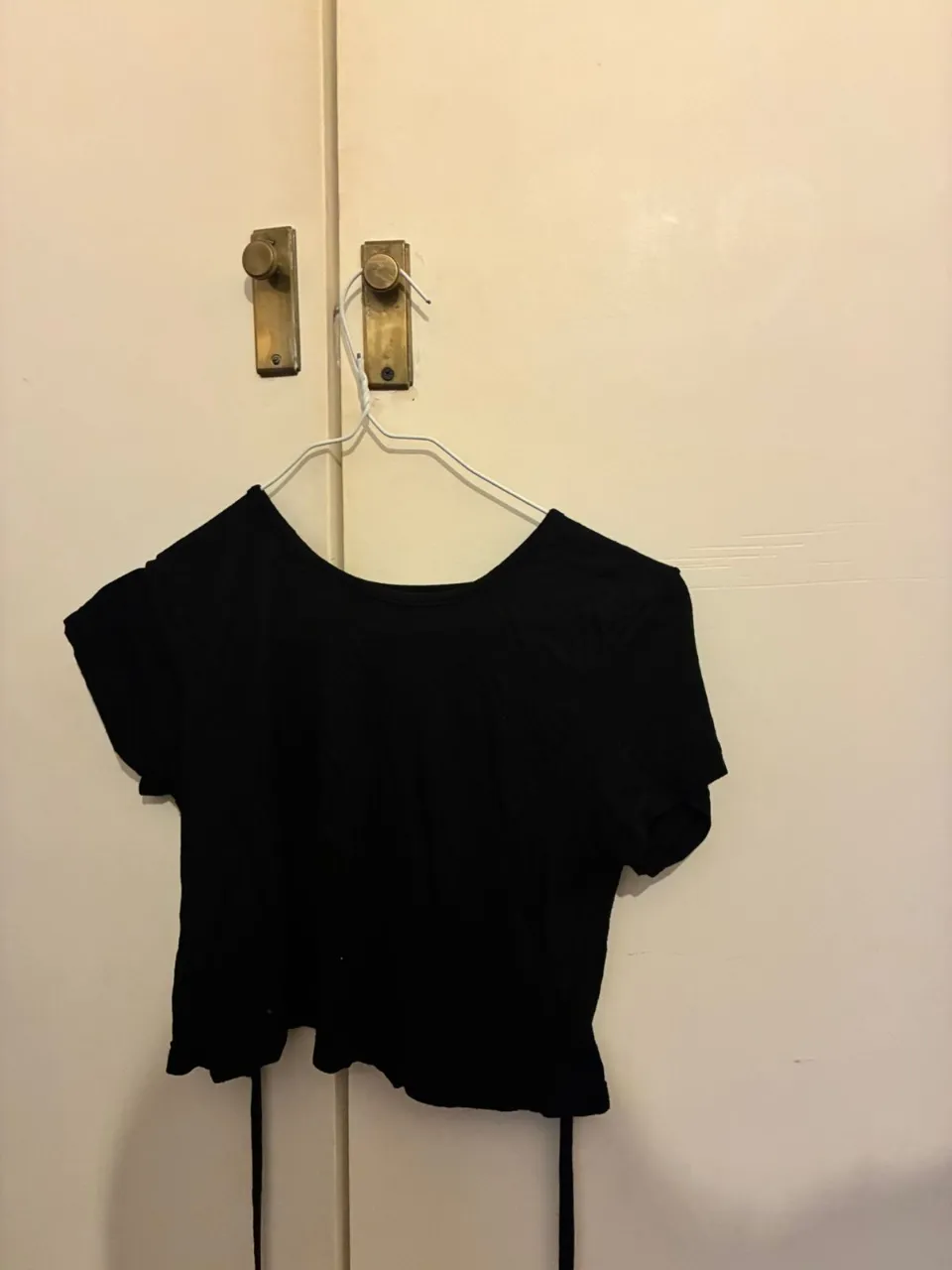 Top negro corto con espalda descubierta. Ideal para un look moderno y versátil.