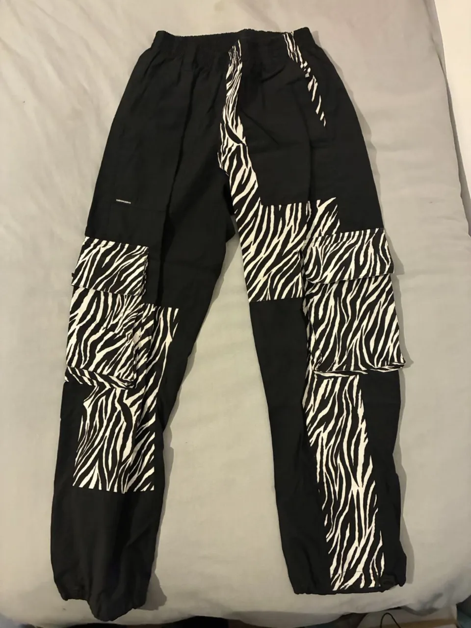 Pantalón cargo negro con parches de estampado de cebra. Talle 3. Ideal para un look urbano y canchero.