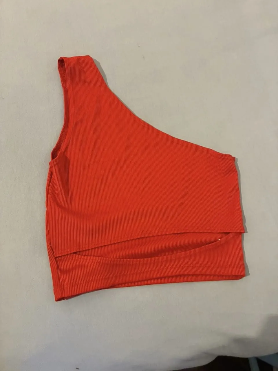 Top asimétrico de un solo hombro, confeccionado en tejido acanalado. Ideal para un look moderno y audaz.