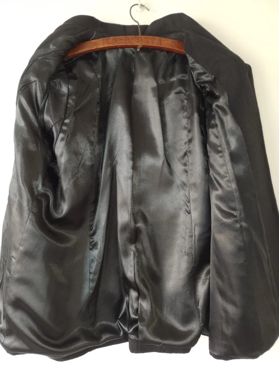 Abrigo corto de paño negro, con cuello solapa y botones dorados. Ideal para un look elegante y abrigado.