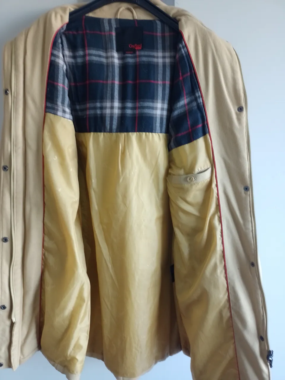 Campera larga color beige con capucha desmontable y detalles de corderoy. Interior forrado con tela escocesa. Ideal para el frío y para un look casual.