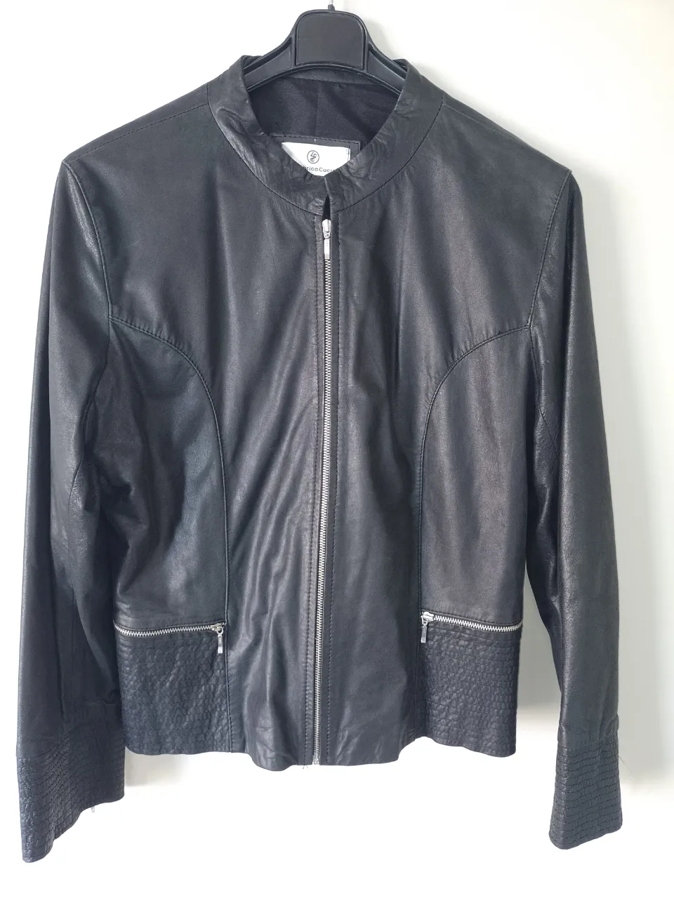 Campera de cuero negra, con cuello mao y cierre al frente. Posee bolsillos con cierre en la parte inferior y detalles texturizados en puños y cintura. Ideal para un look canchero y moderno.