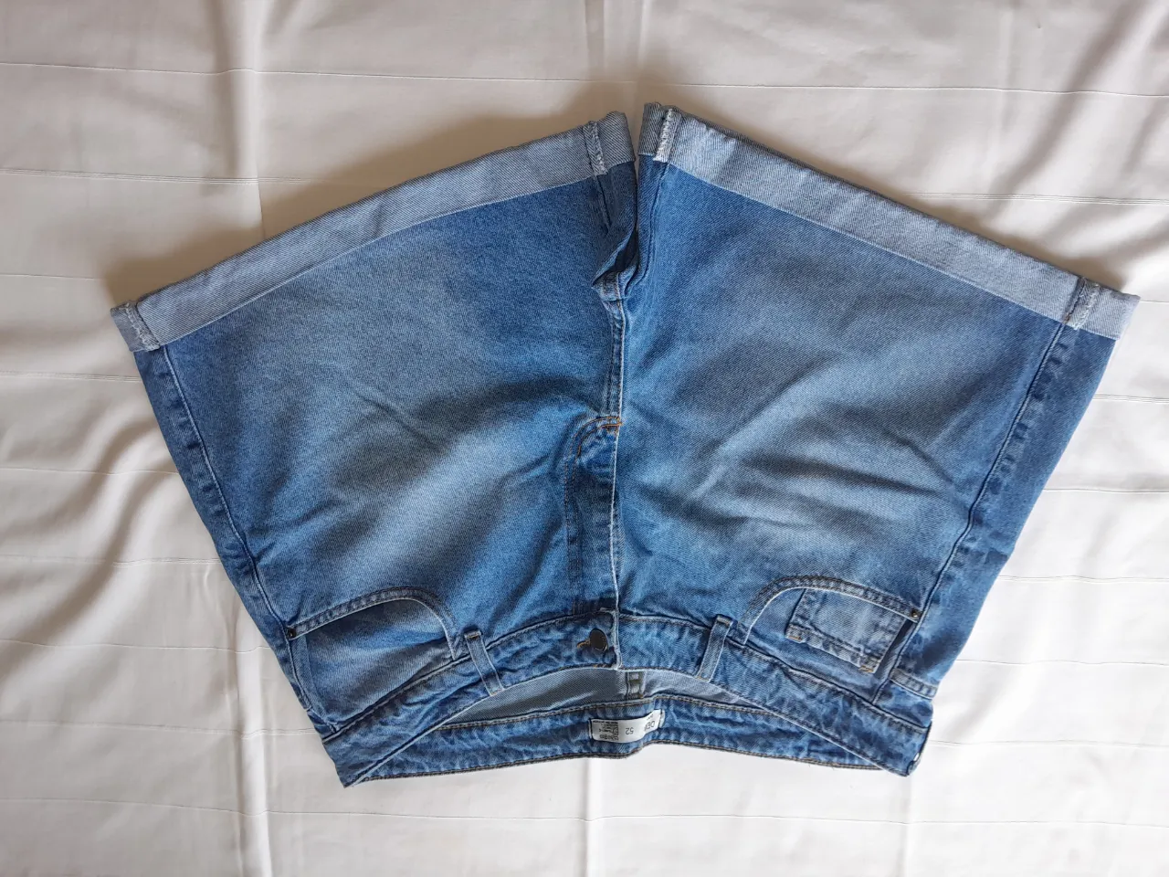 Shorts de jean tiro alto con puños doblados en los bajos. Presentan bolsillos delanteros y traseros.