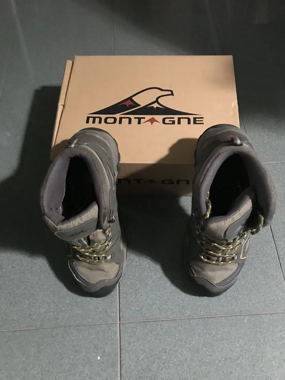 Botas de montaña Montagne, color gris y verde, ideales para trekking y actividades al aire libre. Diseño resistente y cómodo.
