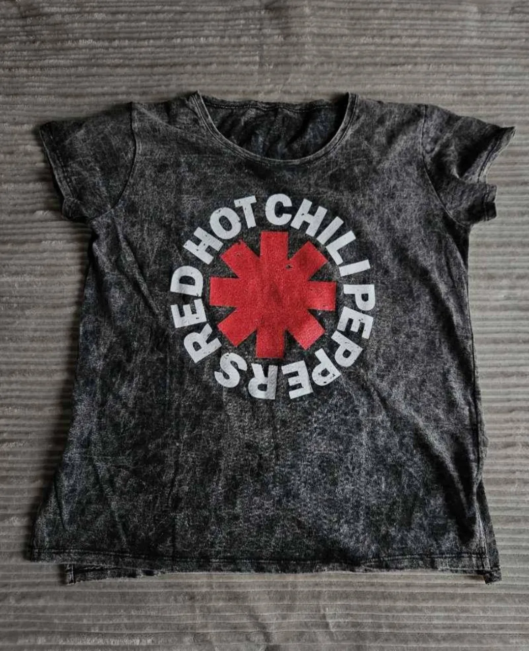 Remera gris jaspeada con estampa del logo de Red Hot Chili Peppers en el frente.