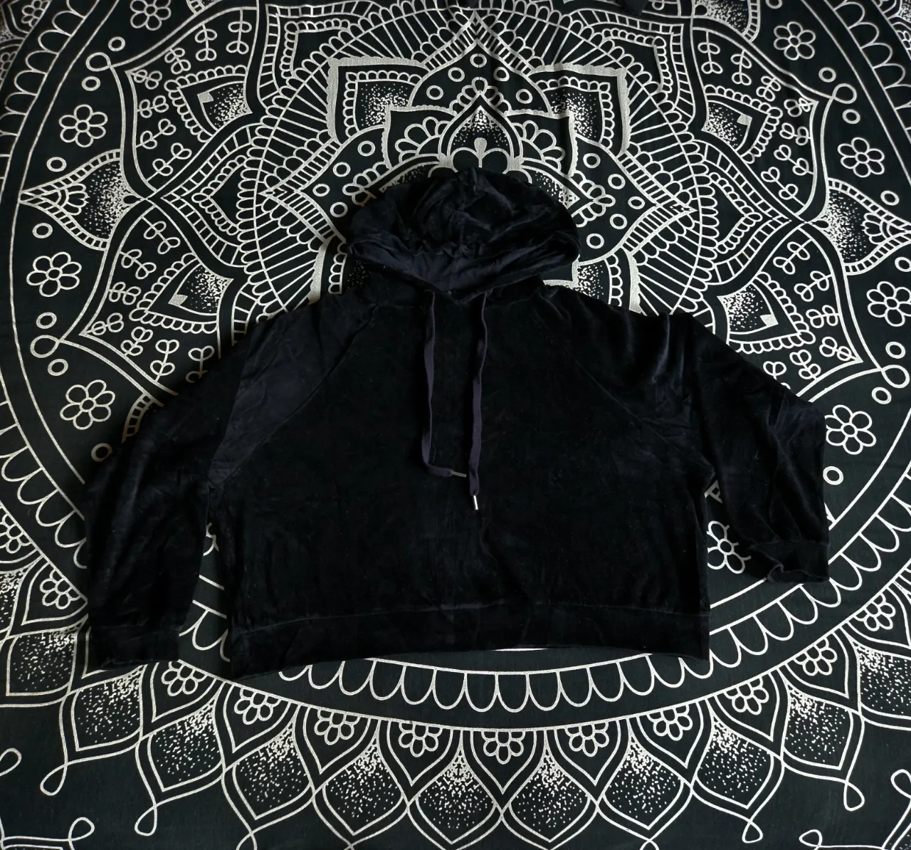 Buzo de plush negro con capucha y cordones. Posee puños y cintura elastizados. Corto, oversize, manga murcielago, marca Complot.