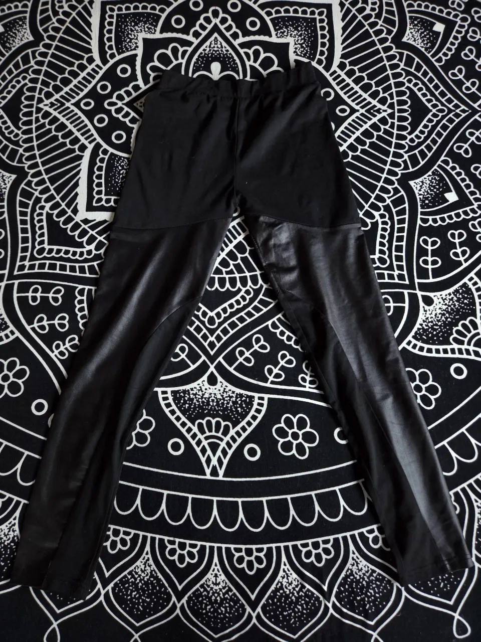 Calza negra con recortes de engomado en las piernas. Tiro medio