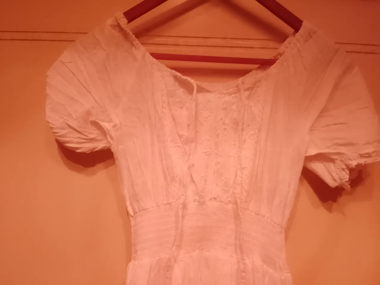 Vestido blanco largo, con detalles de bordado y puntillas. Escote en V con lazo y mangas cortas abullonadas. Ideal para un look romántico y fresco.