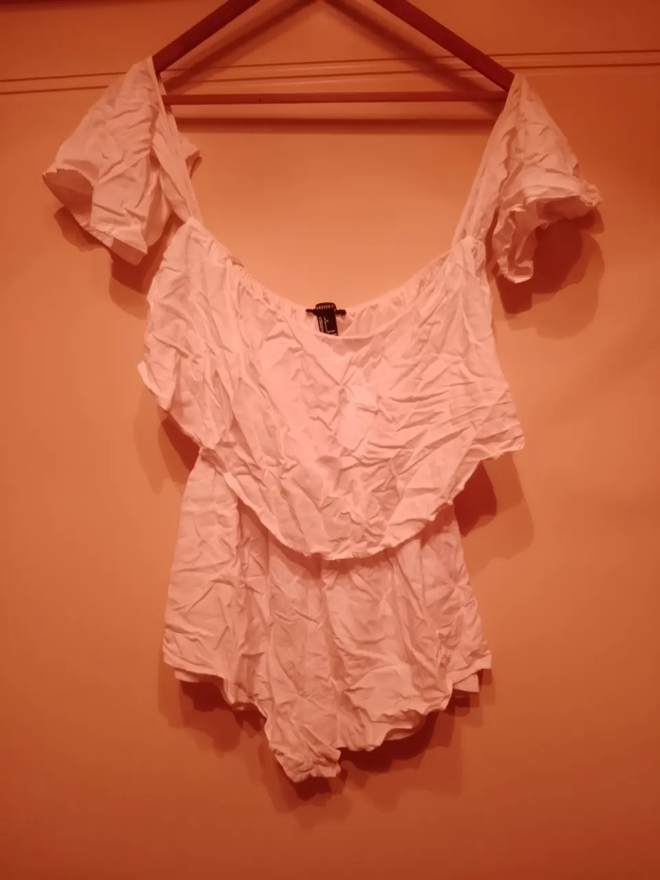 Mono blanco de tela liviana, con volados en las mangas y en la parte superior. Ideal para un look fresco y veraniego.