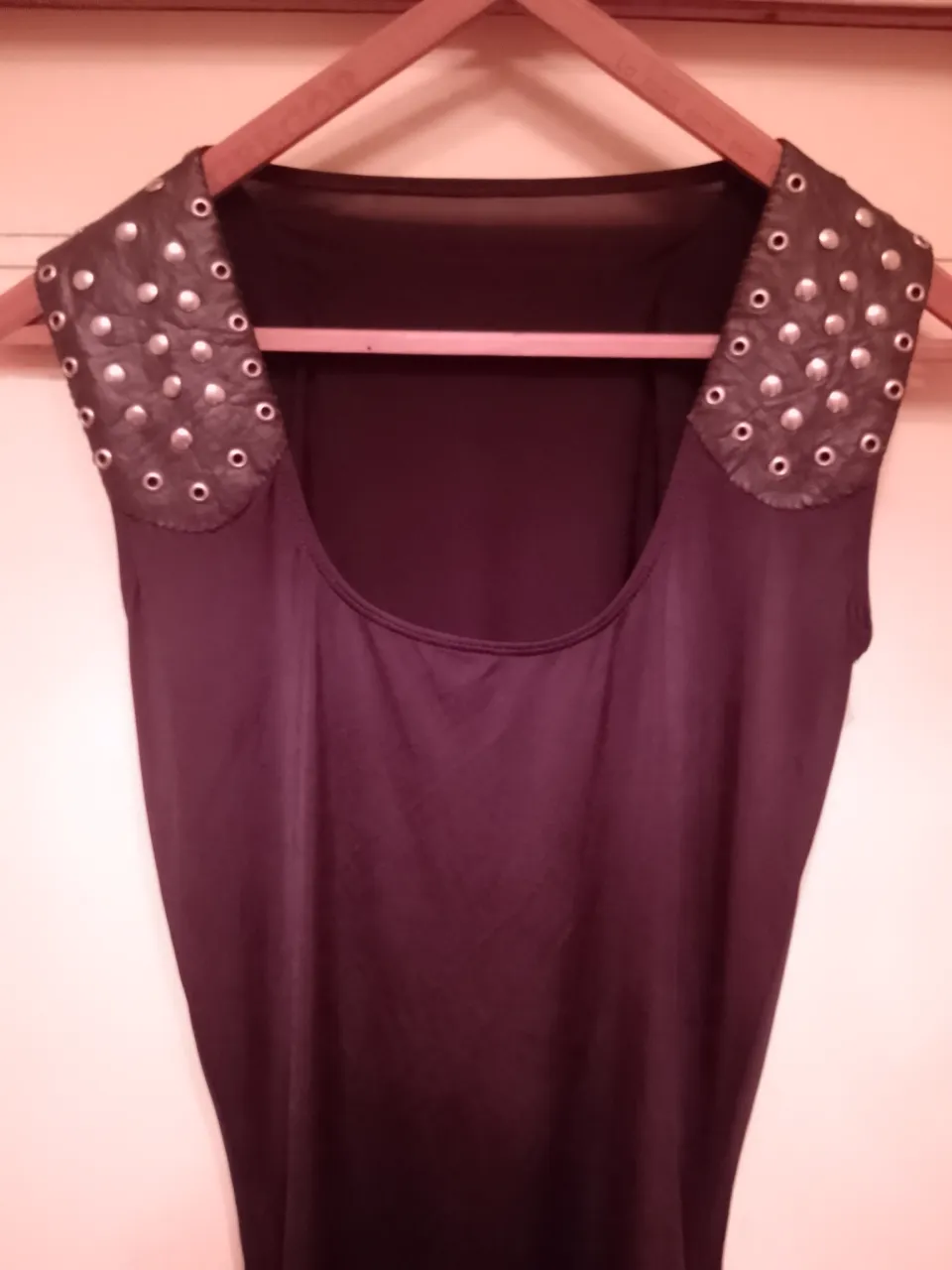 Vestido negro con detalles de tachas plateadas en los hombros. Diseño único y canchero, ideal para un look rocker o de festival.  Outfit impactante.