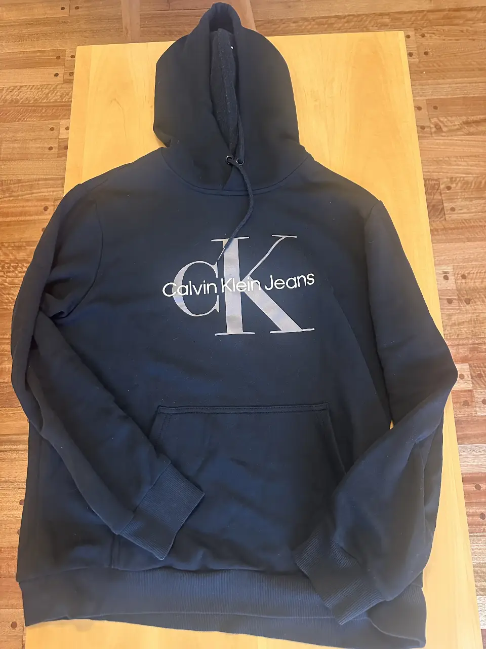 Buzo canguro negro de hombre Calvin Klein Jeans con el logo de la marca en el frente. Ideal para un look casual y cómodo.