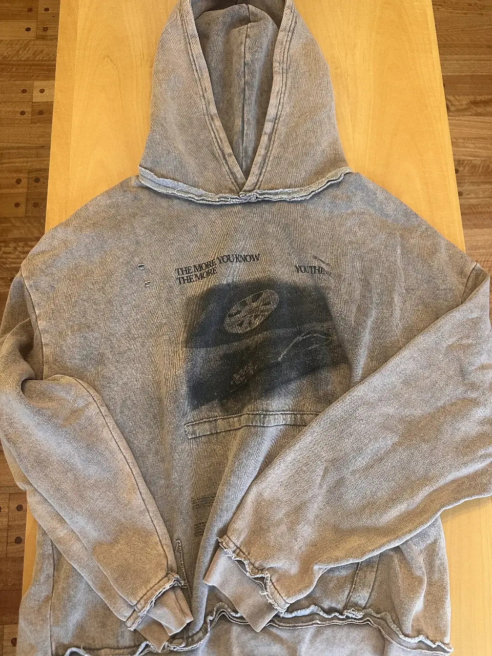 Buzo canguro de hombre, color gris con diseño estampado. Estilo streetwear, ideal para un look casual y cómodo. 