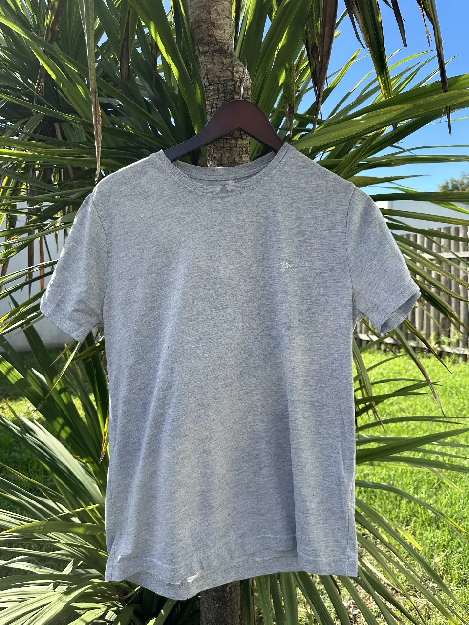 Remera gris de hombre, manga corta, con el logo de Penguin bordado en el pecho. Ideal para un look casual y cómodo.