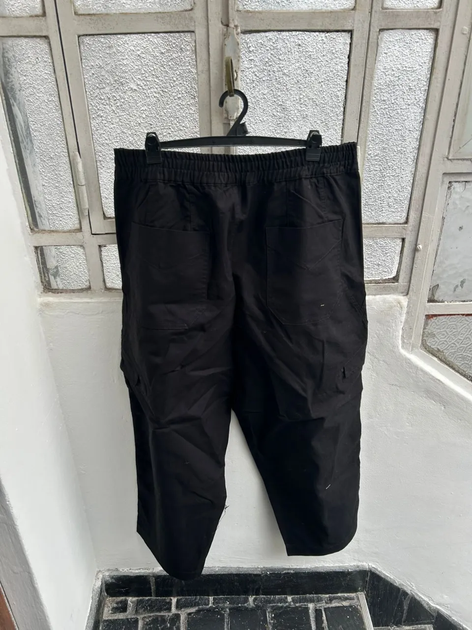 Pantalón cargo negro para mujer, con bolsillos laterales y traseros. Ideal para un look casual y cómodo.