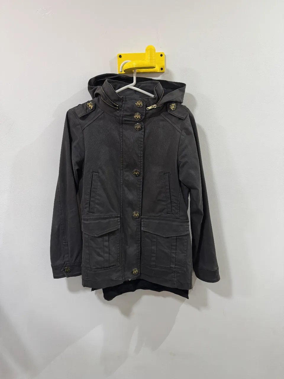 Campera negra con capucha y detalles dorados. Tiene cierre y botones con el logo de la marca. En la espalda tiene un diseño de "Rock and Roll" con brillos. Ideal para un look casual y canchero.