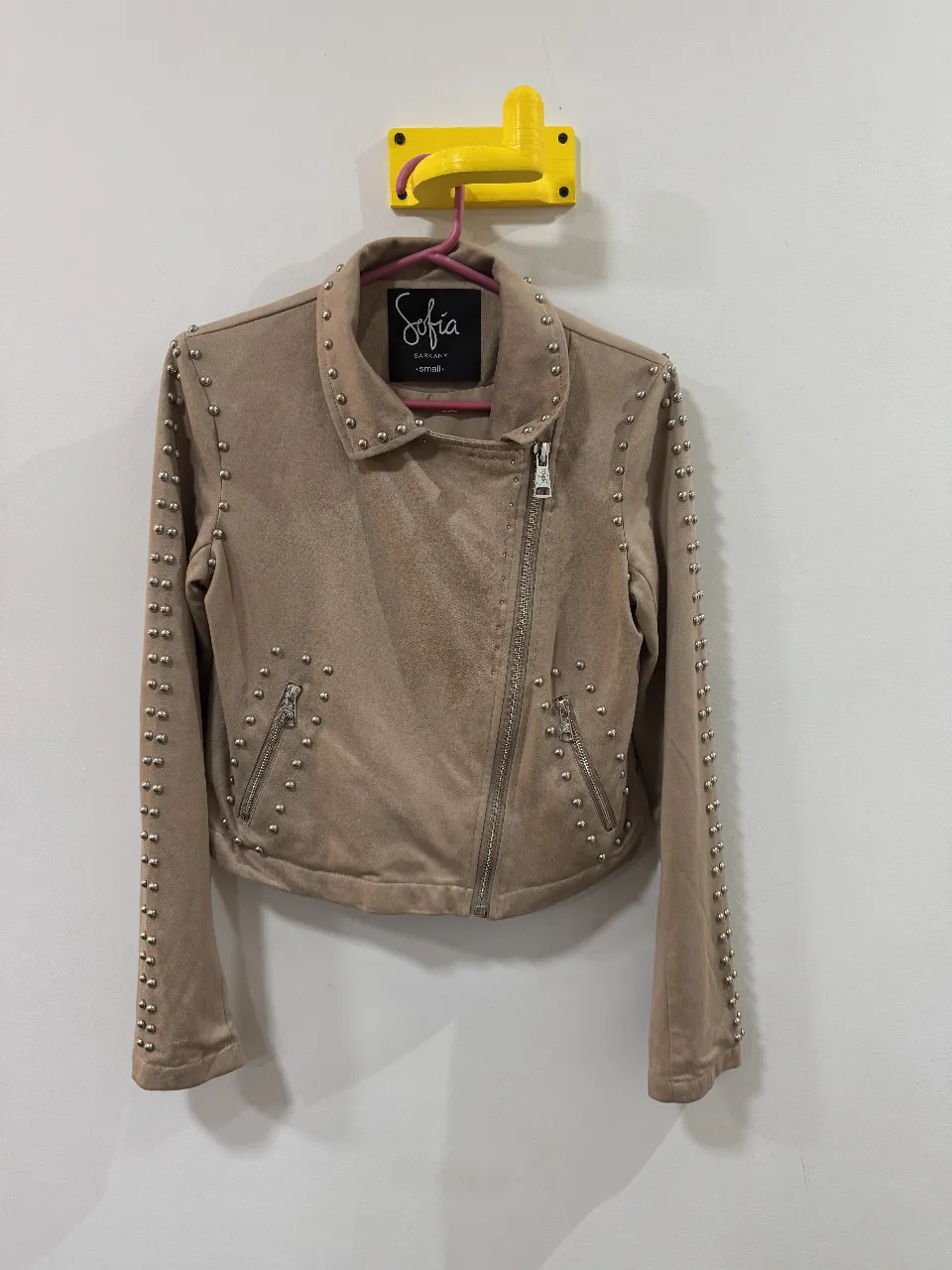 Campera biker de gamuza sintética color crudo con tachas plateadas. Marca Sofia Sarkany. Talle small.